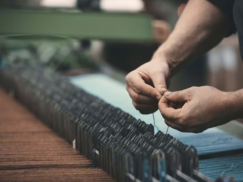 Hands tying threads in weaving machine